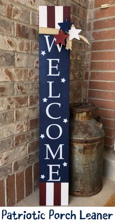 tall wooden porch leaner with "welcome" in white lettering with navy blue background surrounded by red, white, blue stars and stripes